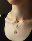 Model wearing Monogram Coin Necklace in all sizes.