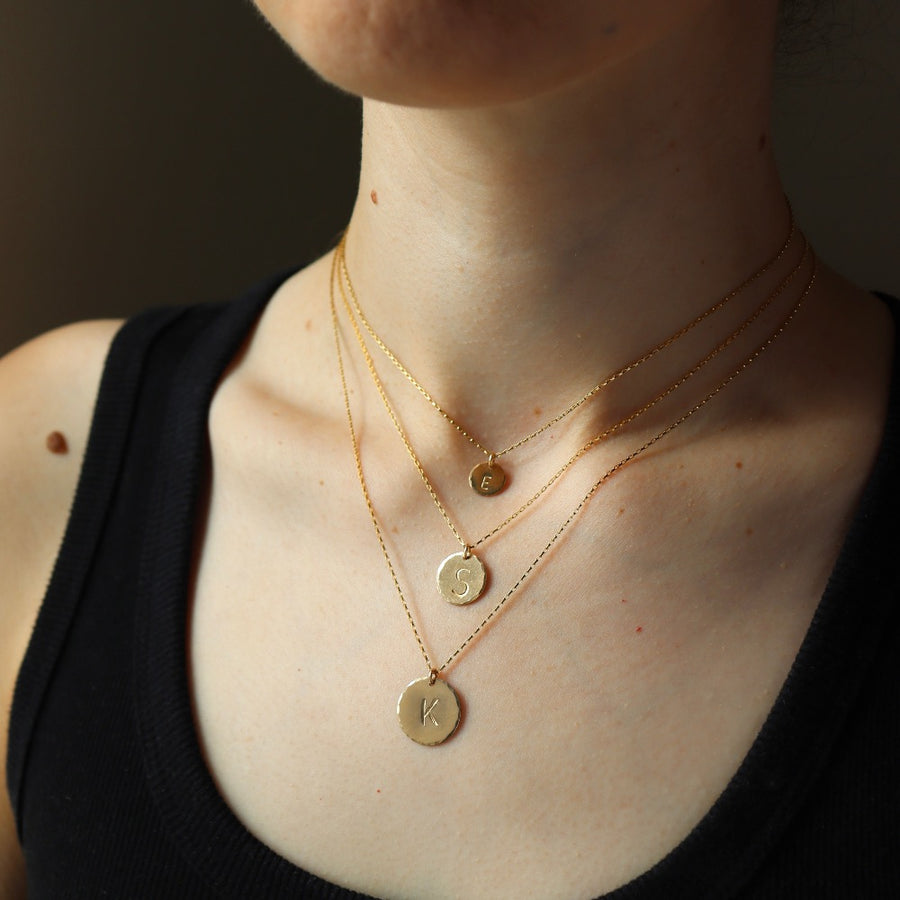 Model wearing Monogram Coin Necklace in all sizes.