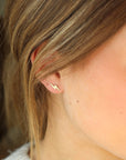 gold fill lightning bolt stud earrings pictured on a model