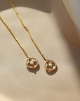 delicate gold fill circle threader earrings with pearl detail, photographed on a ceramic dish