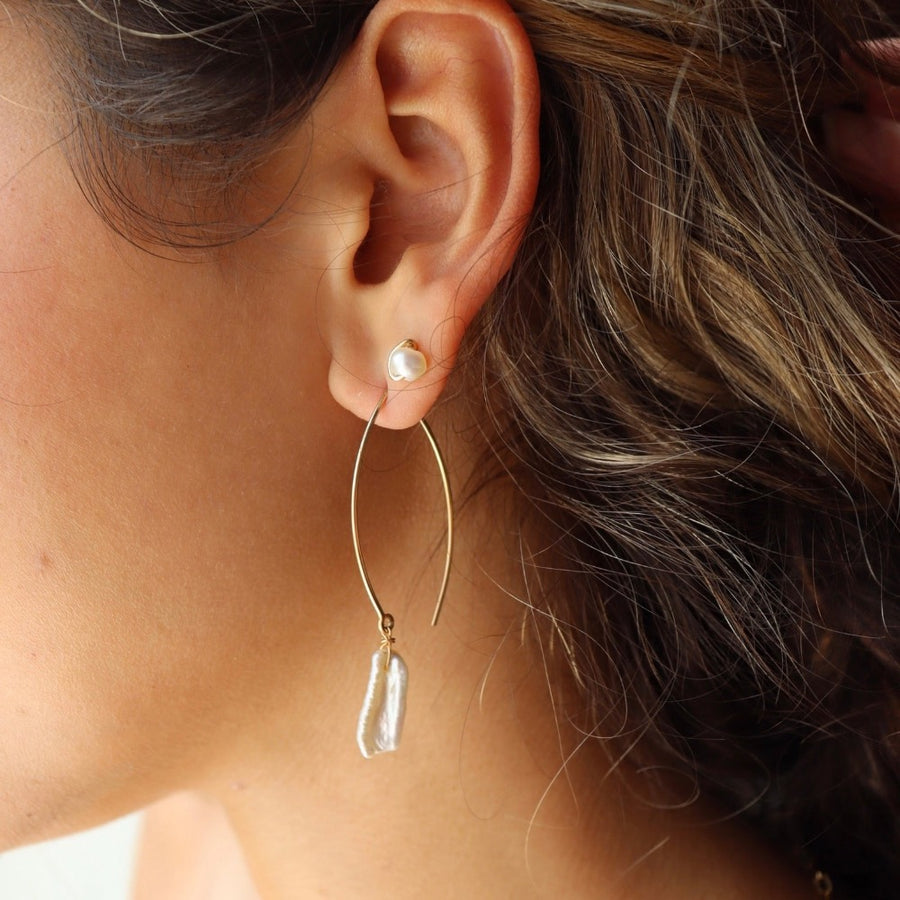 Model wearing 14k gold fill Emma pearl studs paired with the Juno earrings