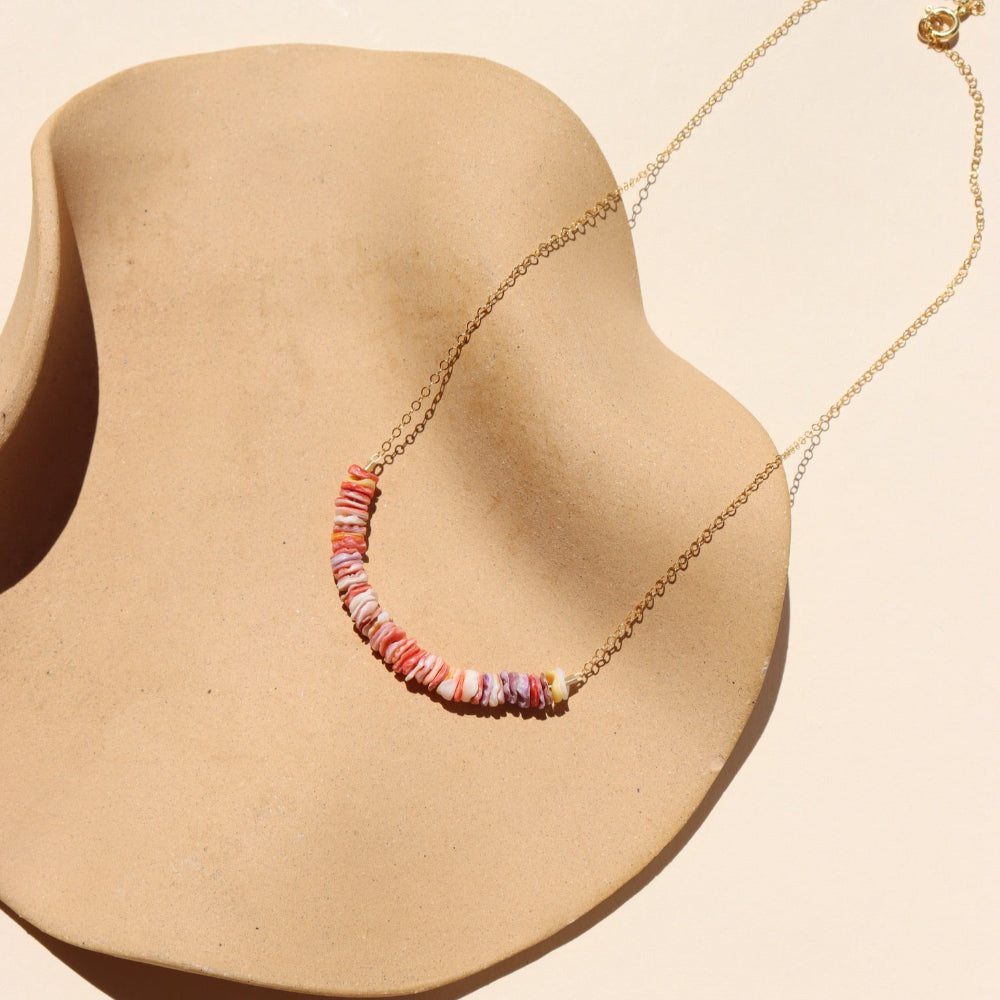 Necklace with colorful beads on a beige dish 
