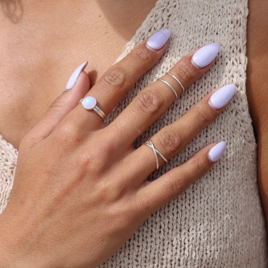 model wearing sterling silver ring with blue lace agate stone paired with sterling silver rings