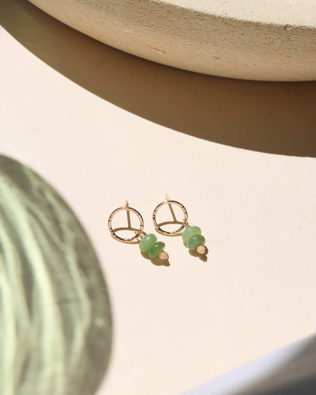 14k gold fill circle studs with opals and coral beads on a light dish