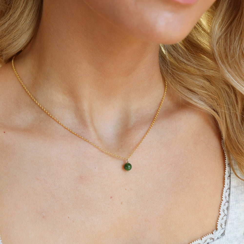 Model is wearing a 14k gold fill small rolo chain featuring a jade ball gemstone.