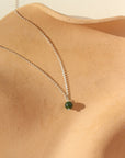 A sterling silver small rolo chain featuring a jade ball gemstone. Necklace is displayed on a orange dish. 