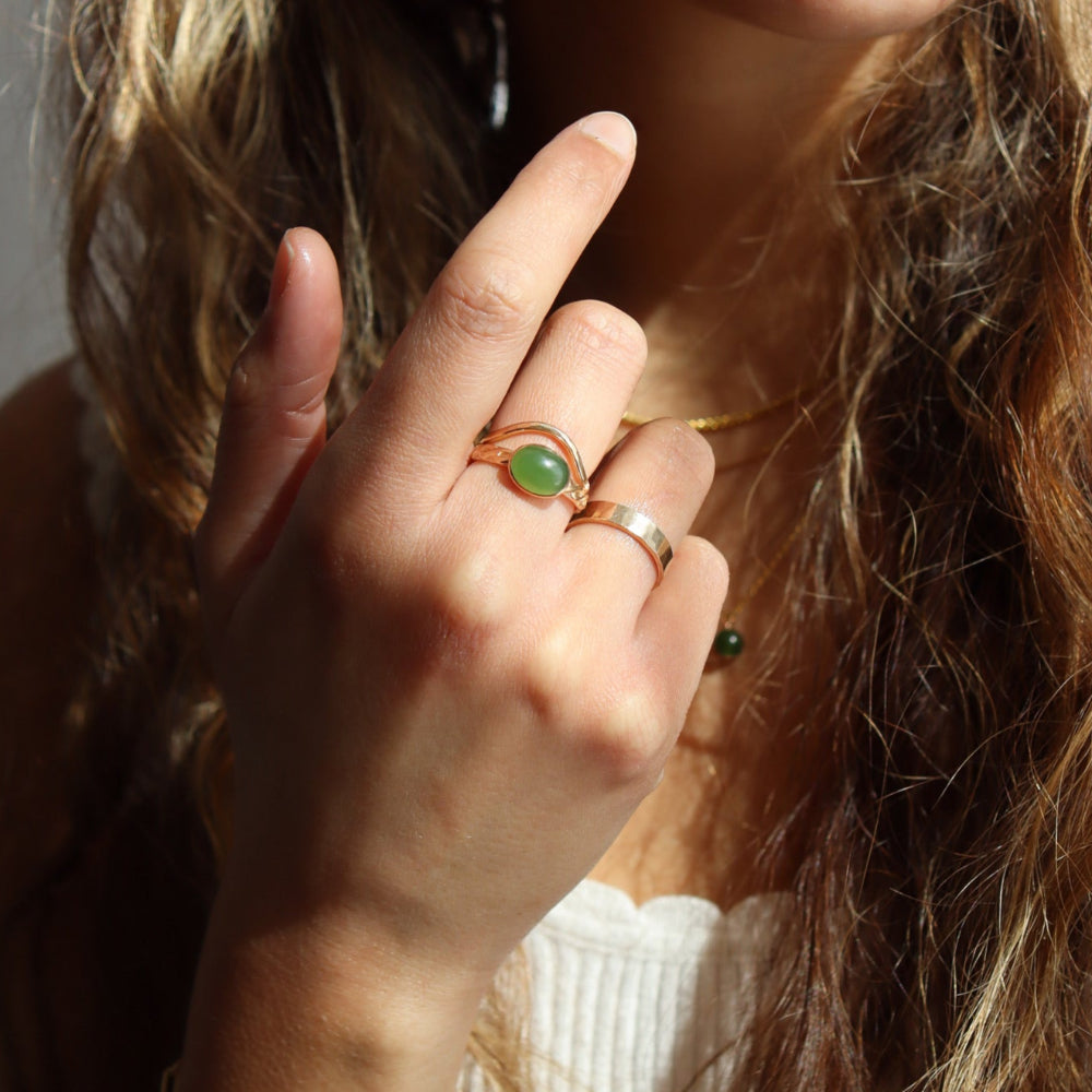 Model is wearing a 14k gold fill entwined band with a 8x10 jade gemstone in a gold bezel. Also stacked with a 14k god fill plunge ring creating the perfect stack. 