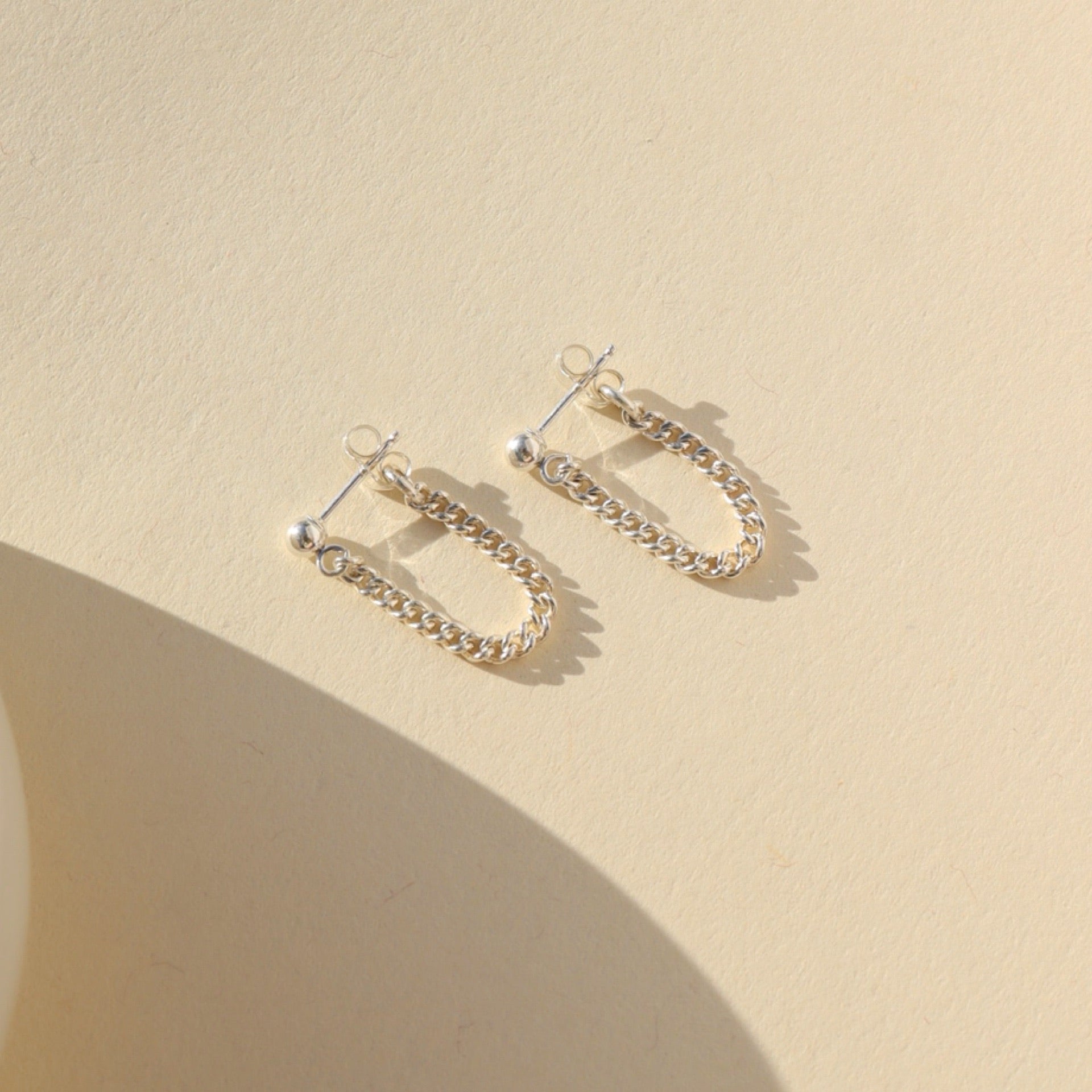 sterling silver small curb chain stud earrings on a light background
