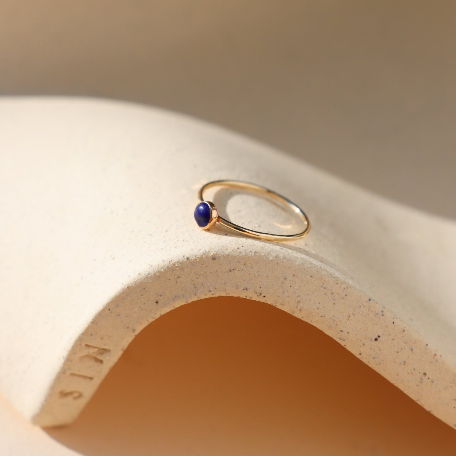 14k gold fill bezel ring with a 4mm lapis lazuli stone in the sunlight
