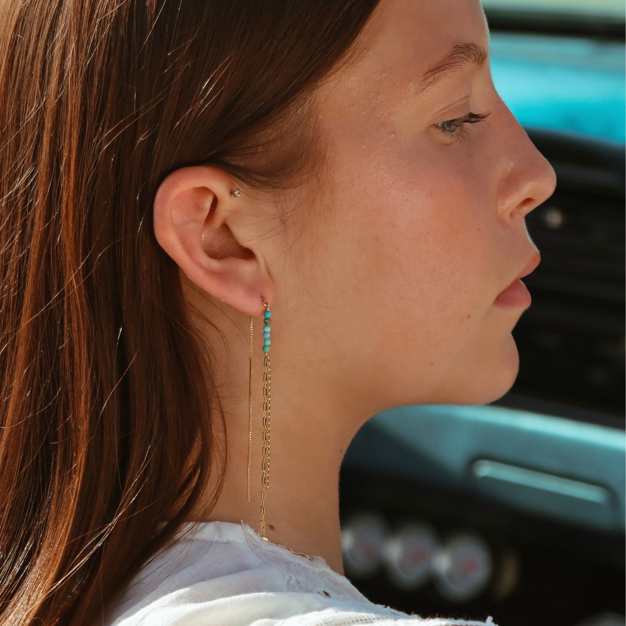 model wearing threader earrings with turquoise stones