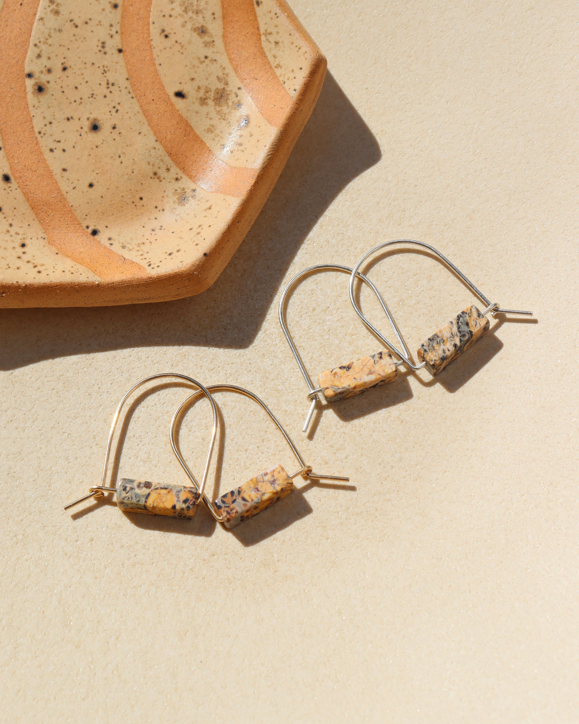 14k gold fill and sterling silver hand shaped arch earrings with leopard jasper stones on a light background