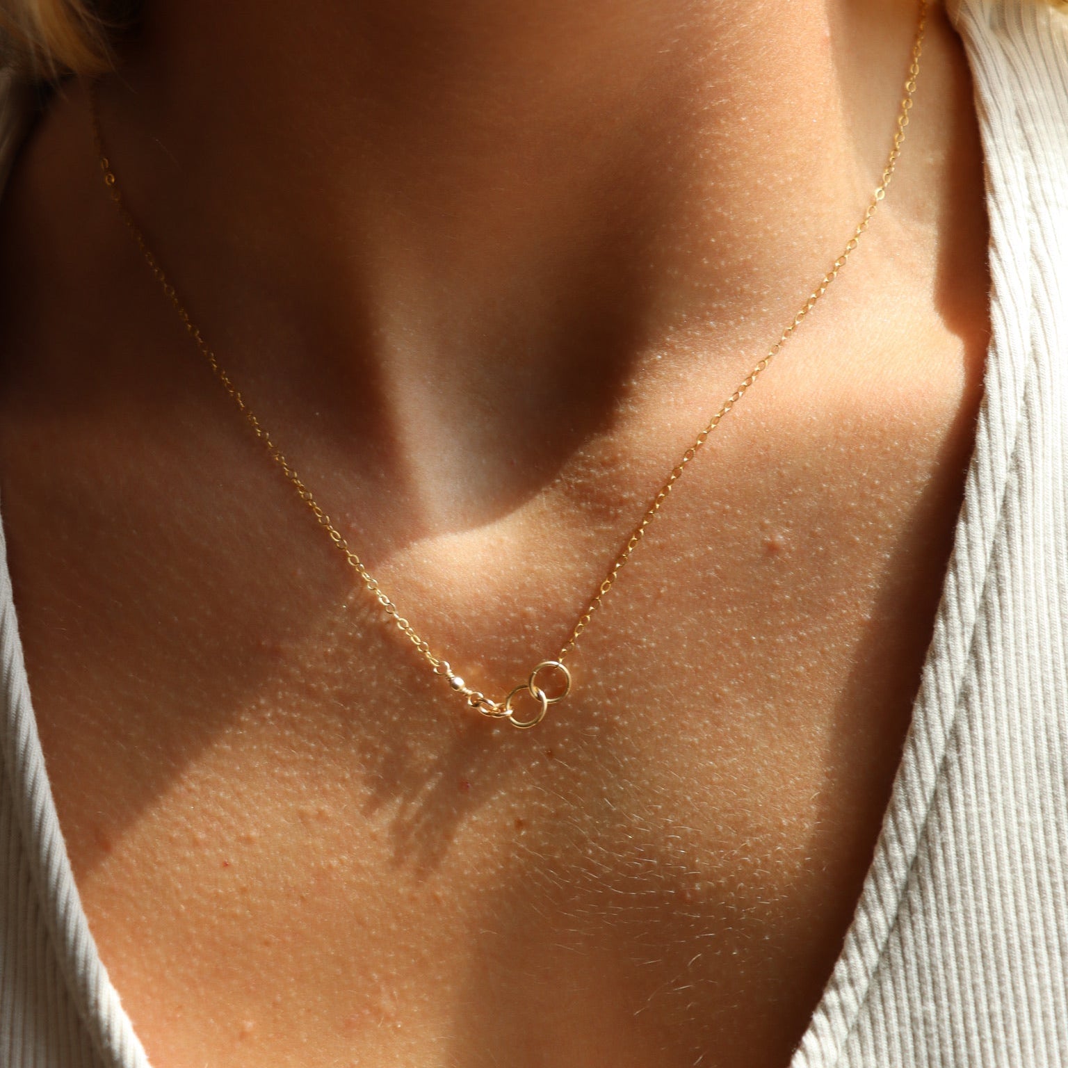 model wearing 14k gold fill delicate chain necklace with jump rings signifying a family lineage 