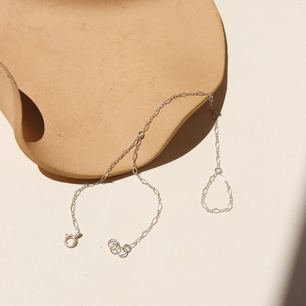 sterling silver hand chain on a light dish
