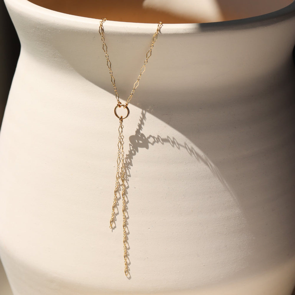Gold lariat necklace with circle pendant and double chain drop