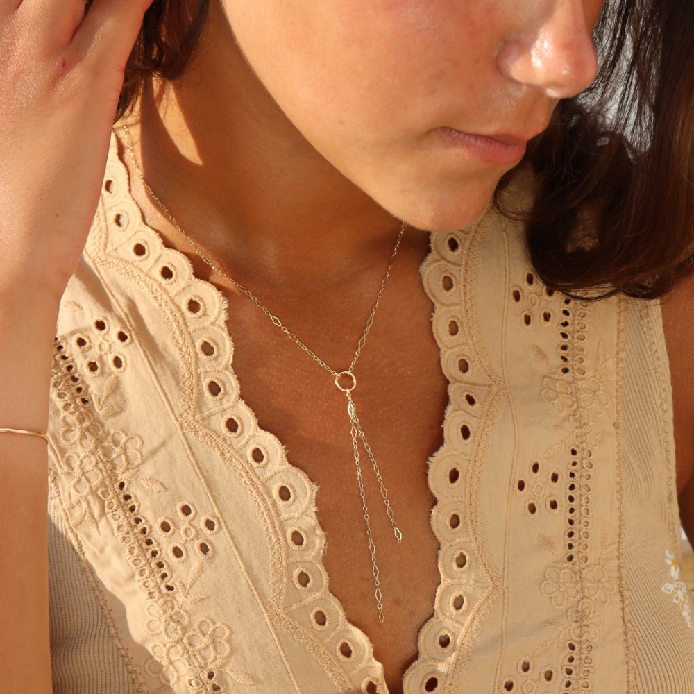 Model wearing Gold lariat necklace with circle pendant and double chain drop