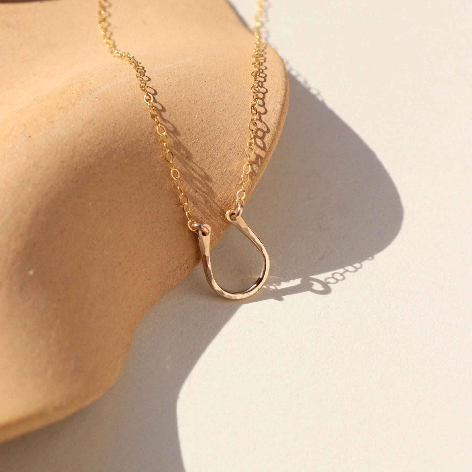 14k gold fill Lucky Charm Necklace. This Necklace features a horseshoe shape with hammering on one side. The horseshoe meaning lucky is connected with the simple chain.