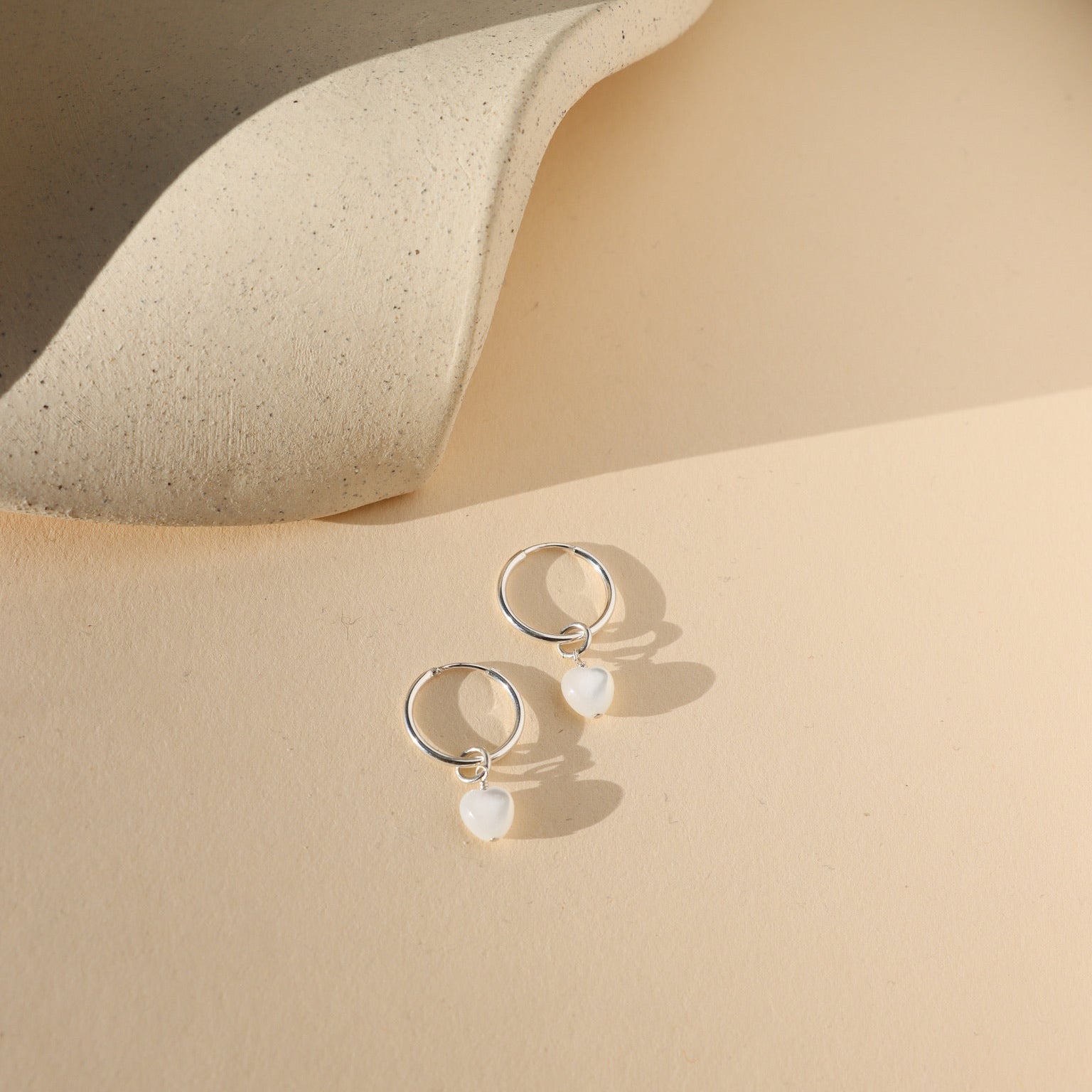 mother of pearl heart beads in sterling silver on sterling silver simple hoops in the sunlight