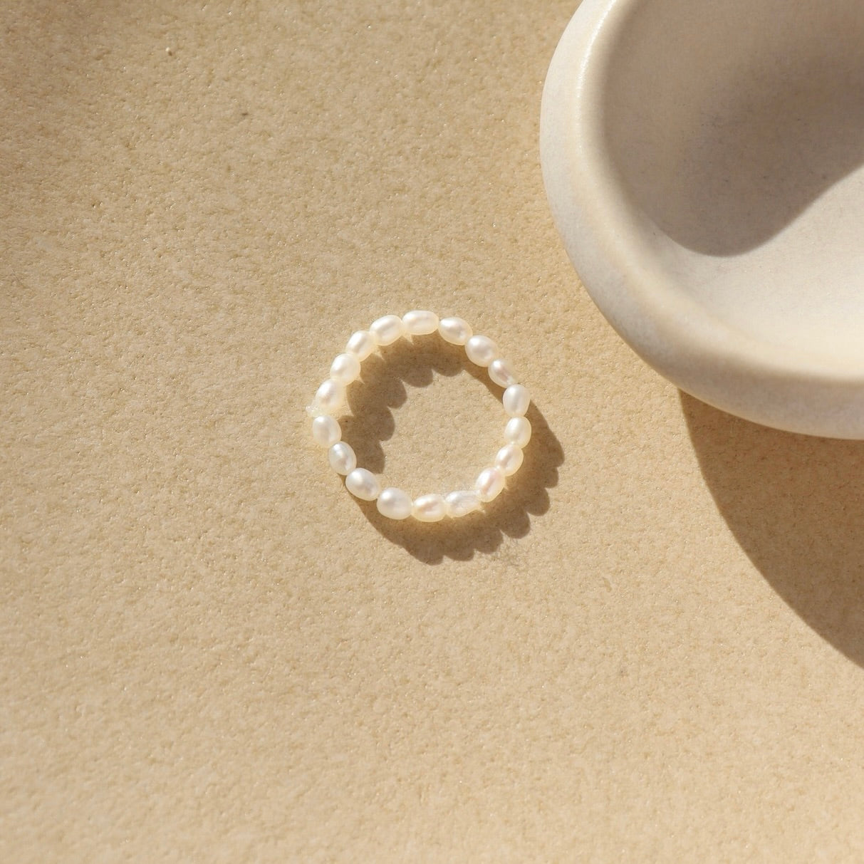 Margot ring laid on a tan plate in the sunlight.