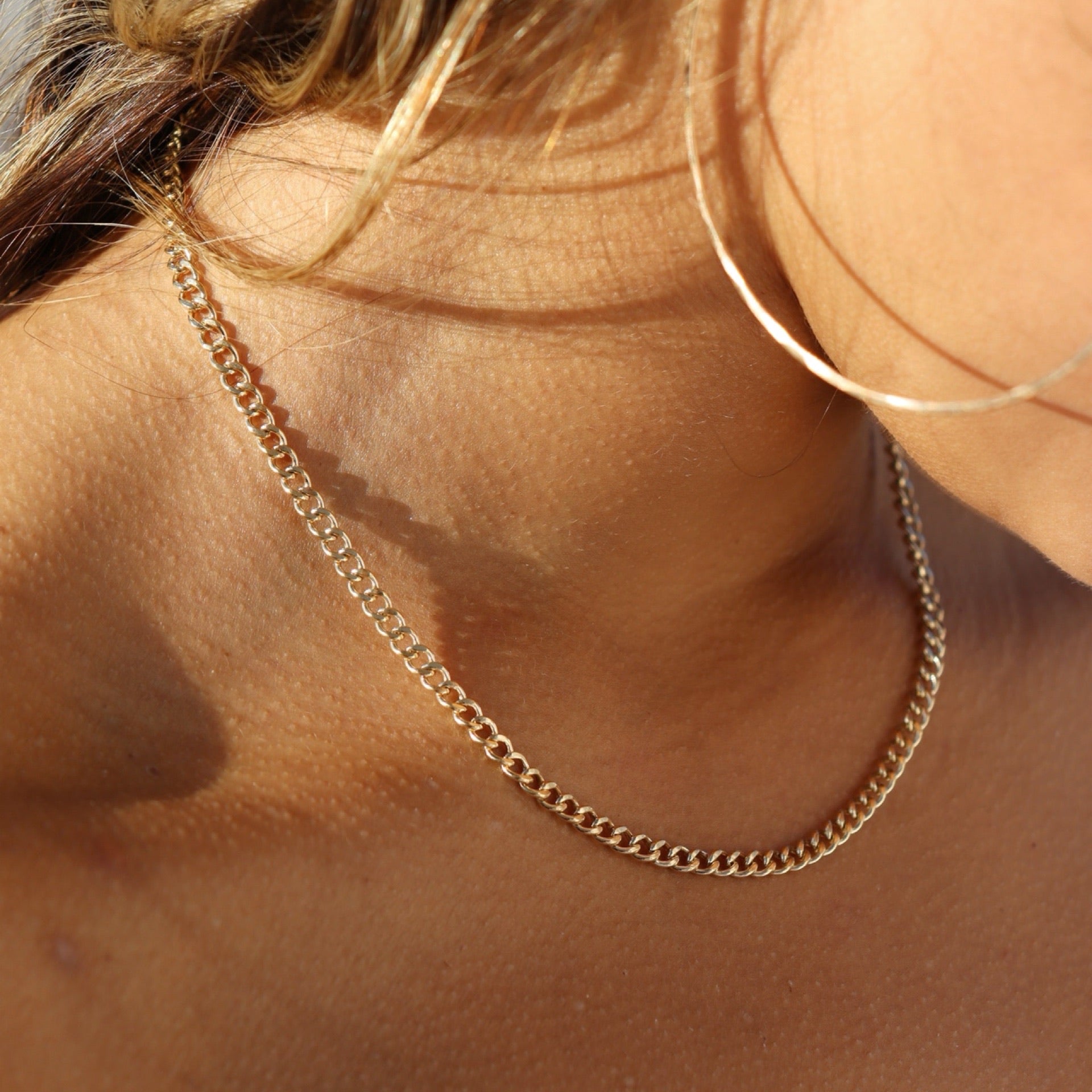 model wearing 14k gold fill chain necklace in the sunlight