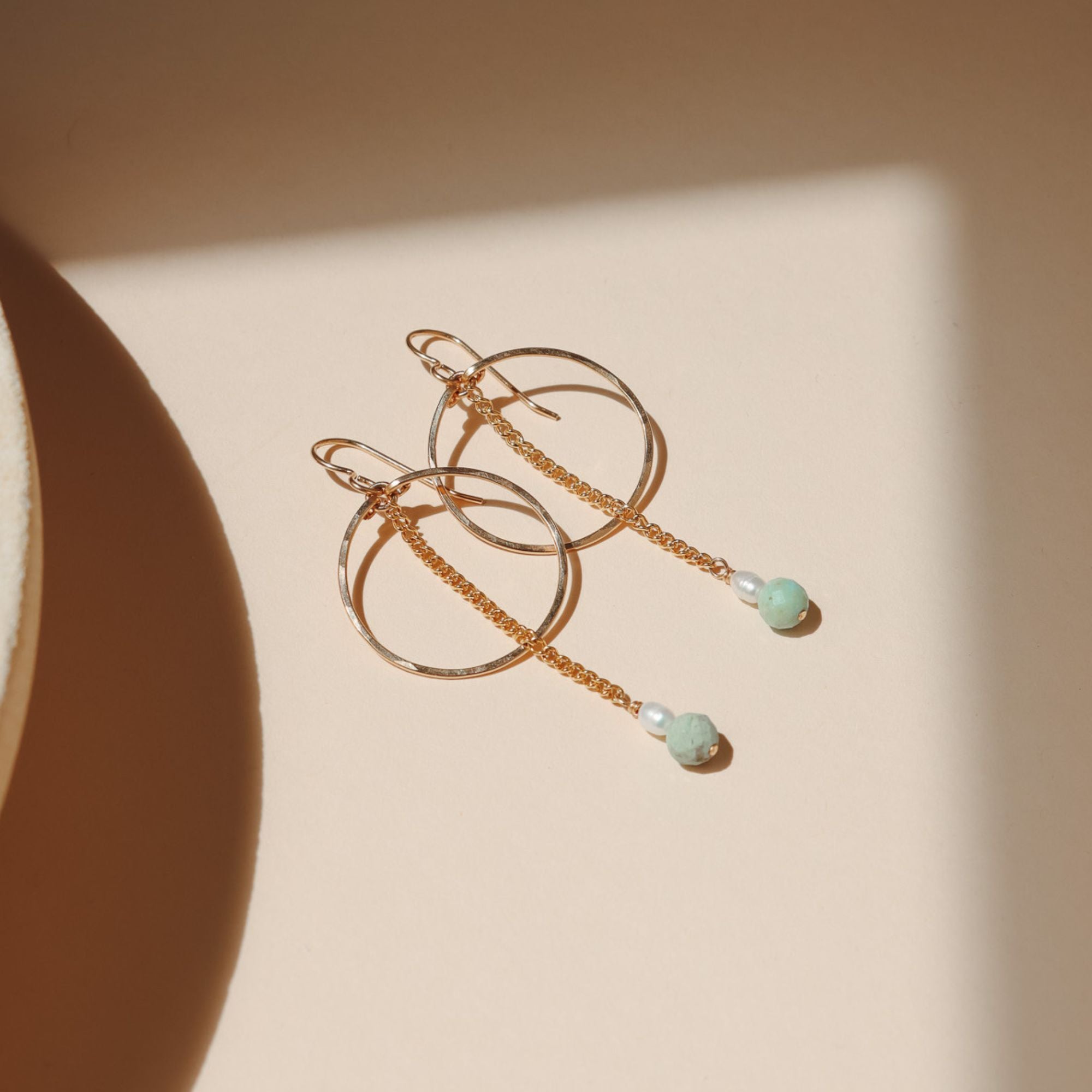 14k gold fill hoops with chain, pearl, and turquoise beads in the sunlight