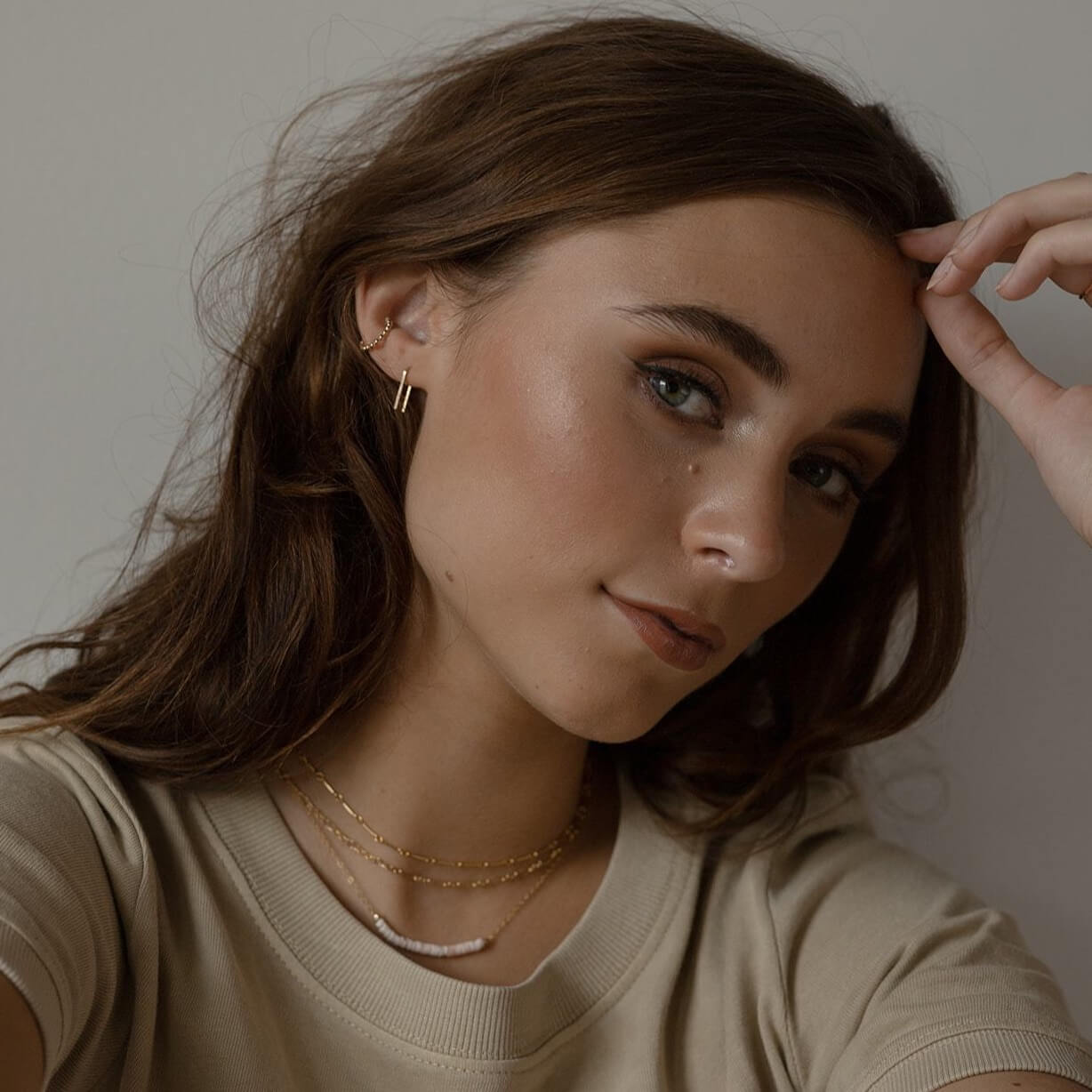 model wearing 14k gold fill staple shaped earrings