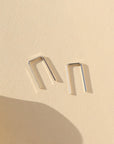 sterling silver mini staples shaped earrings on a light background
