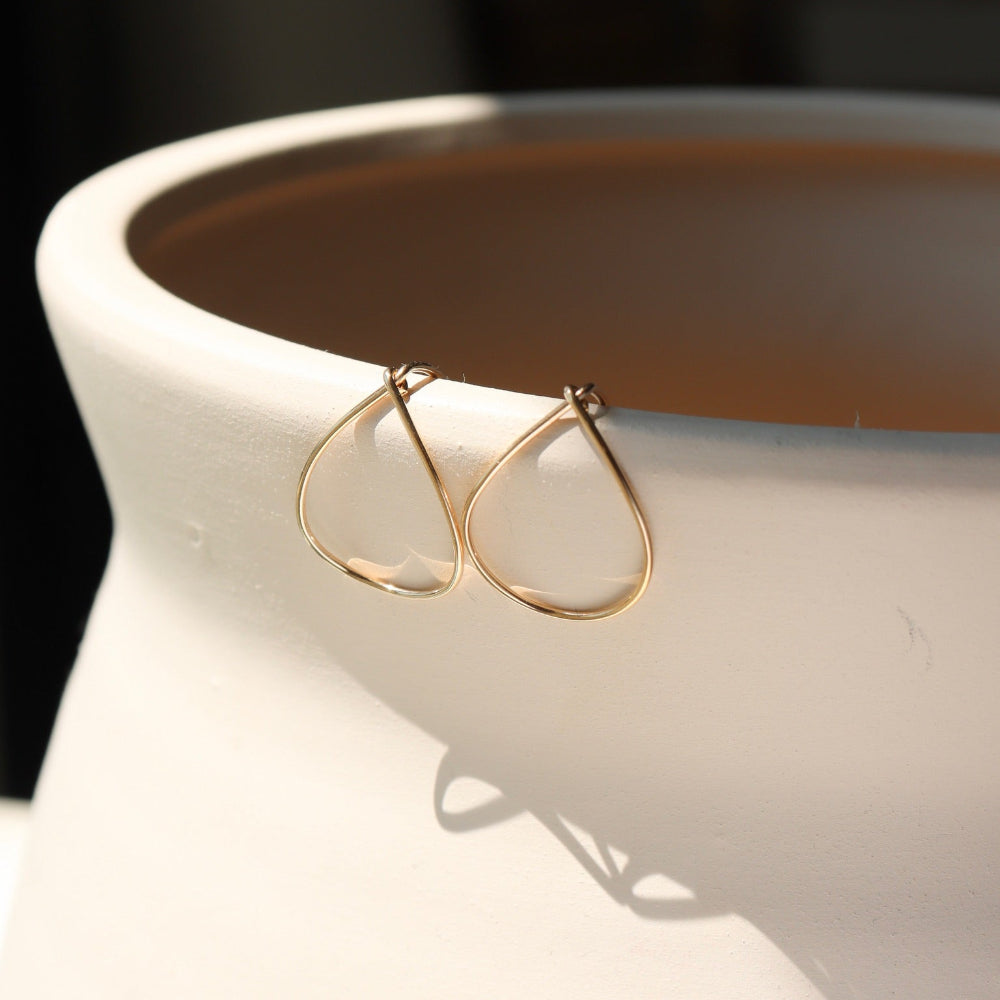 14k gold fill teardrop shaped earrings on a light vase