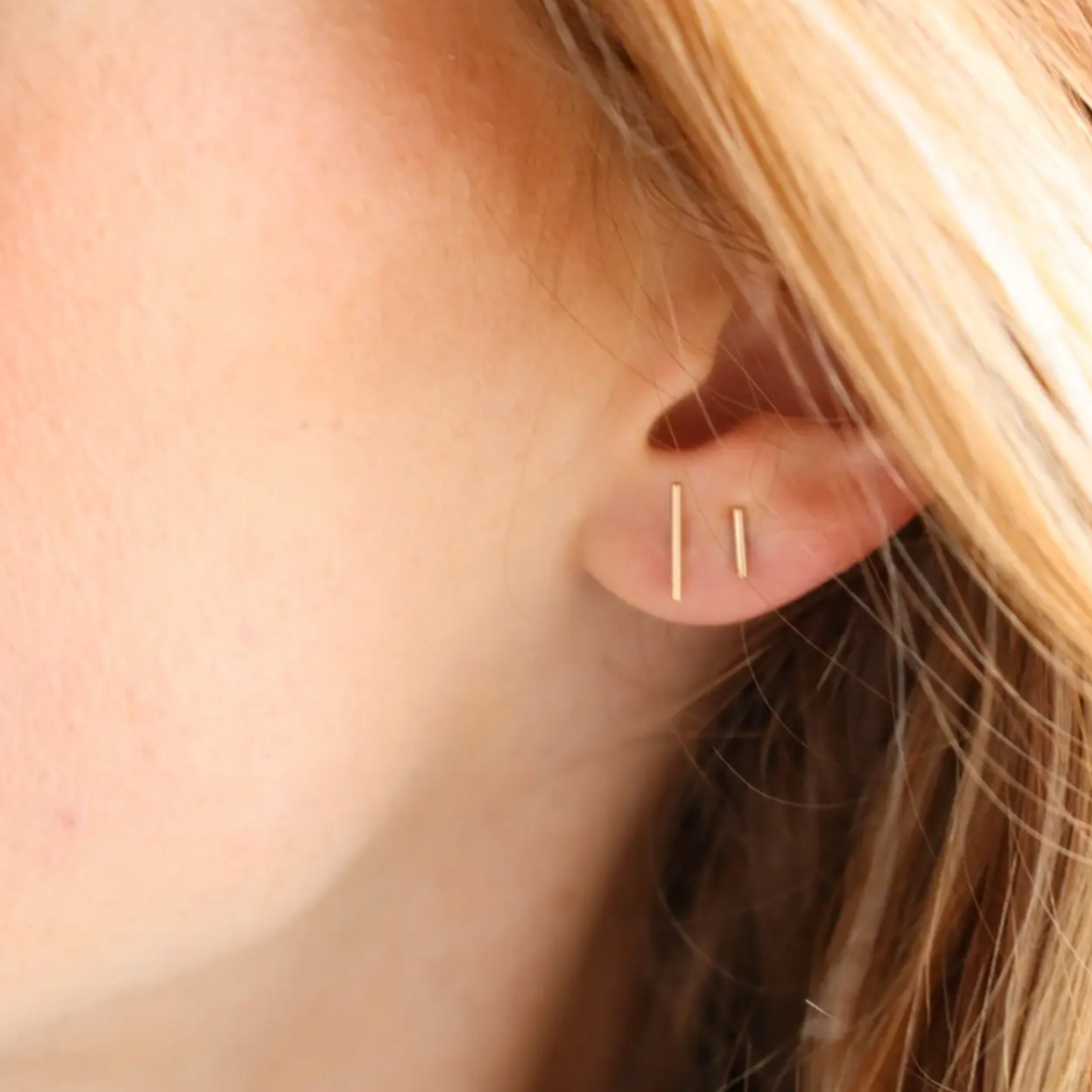 Model wearing 14k gold fill bar studs