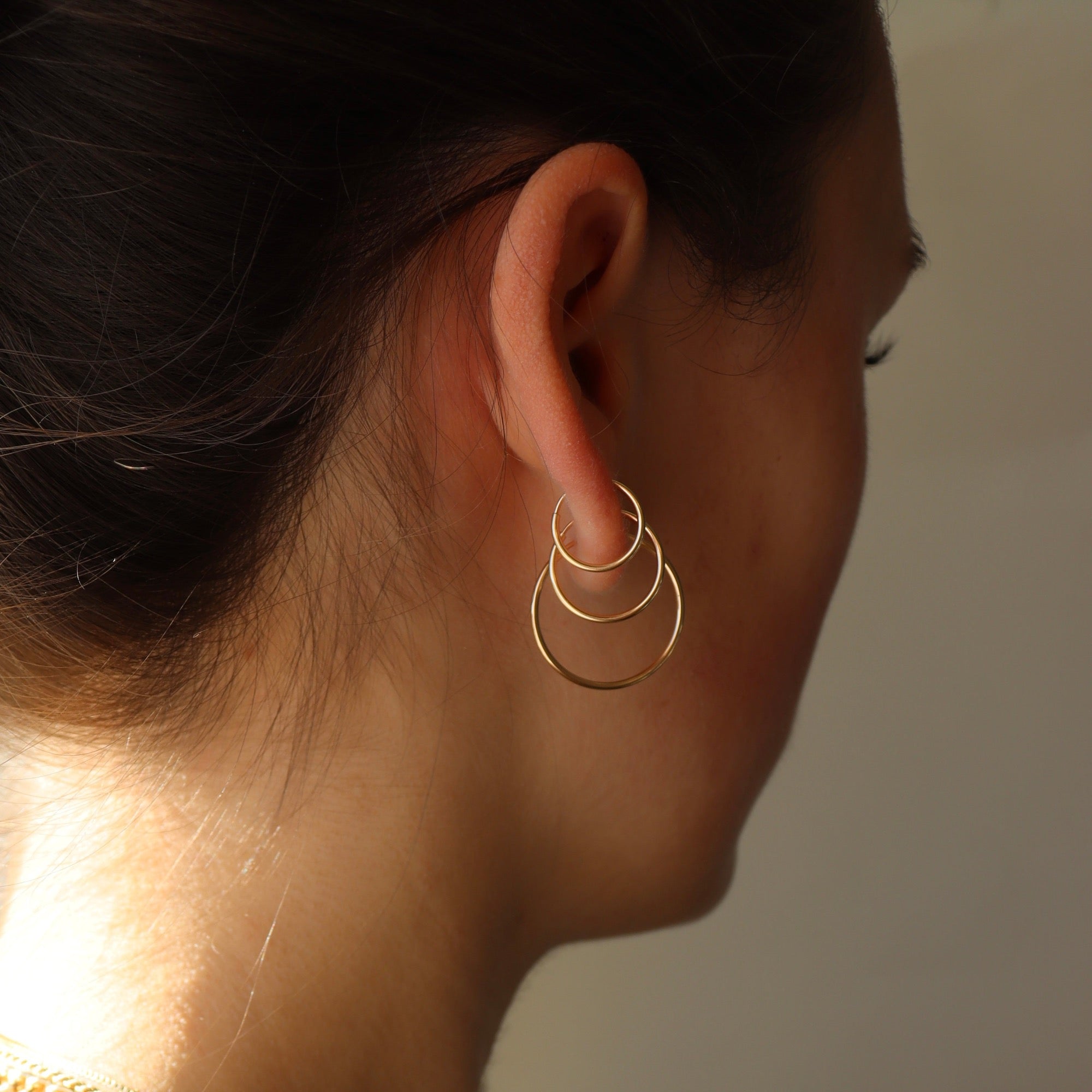 Model wearing 14k gold fill goldie hoops.