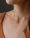 Model wearing 14k gold fill starlight choker. This choker is perfect for layering. This Necklace features circle disc that are linked together.