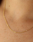 Model Wearing 14k Sunny chain. This necklace features a simple chain with an extra sparkle every 1/2".