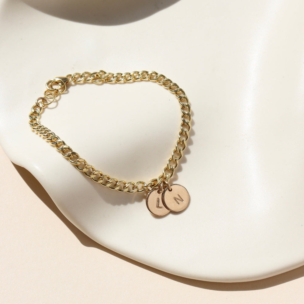 14k gold fill curb chain bracelet with hand stamped discs on a light dish