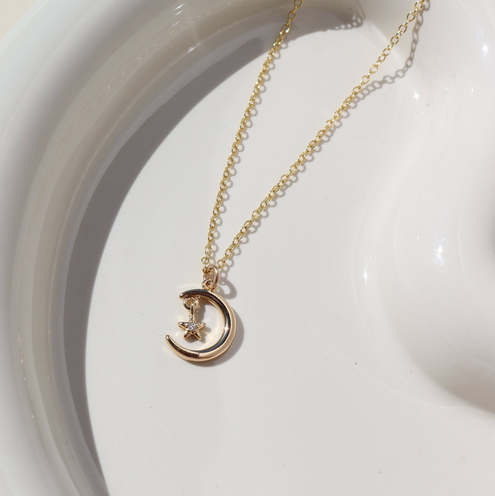 Moon Star Charm Necklace on a white plate in 14k gold filll