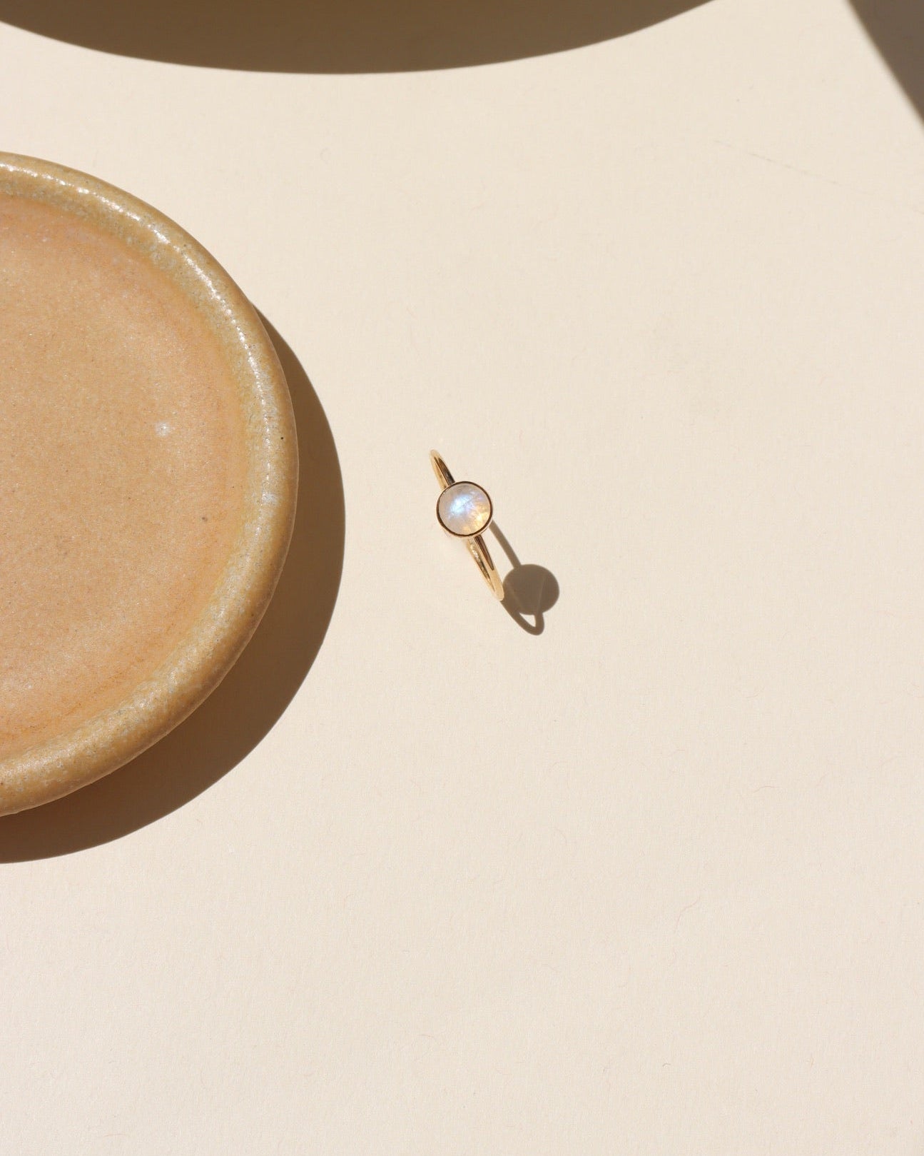 Close-up of stackable moonstone glow ring with iridescent shimmer in gold fill