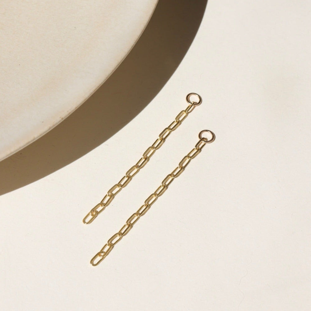14k gold fill long paperclip chain dropped from a 4mm jump ring, displayed on a cream backdrop in the sunlight 