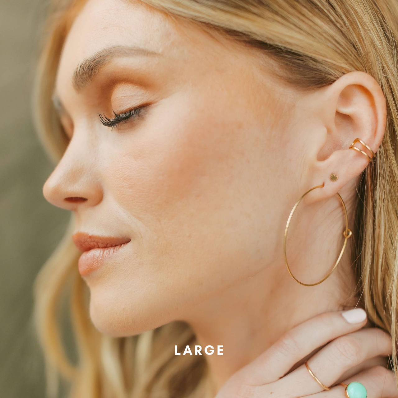 model wearing 14k gold fill hammered hoop earrings paired with 14k gold fill heart stud earring and 14k gold fill ear cuff