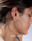 model wearing extra large 14 gold fill hammered hoop earrings with 14k gold fill spiral hoop earrings