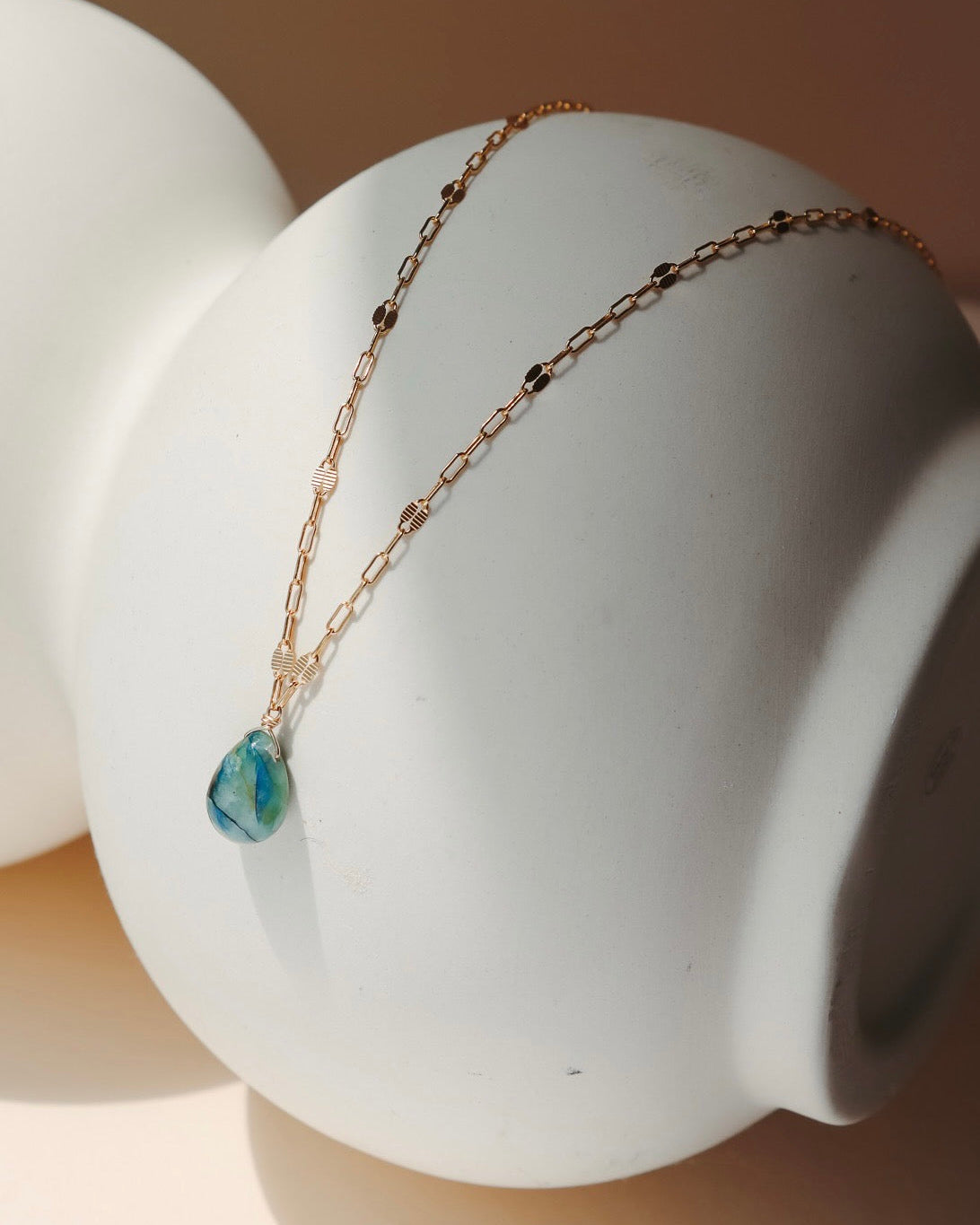 14k gold fill chain necklace with teardrop stone pendant in the sunlight