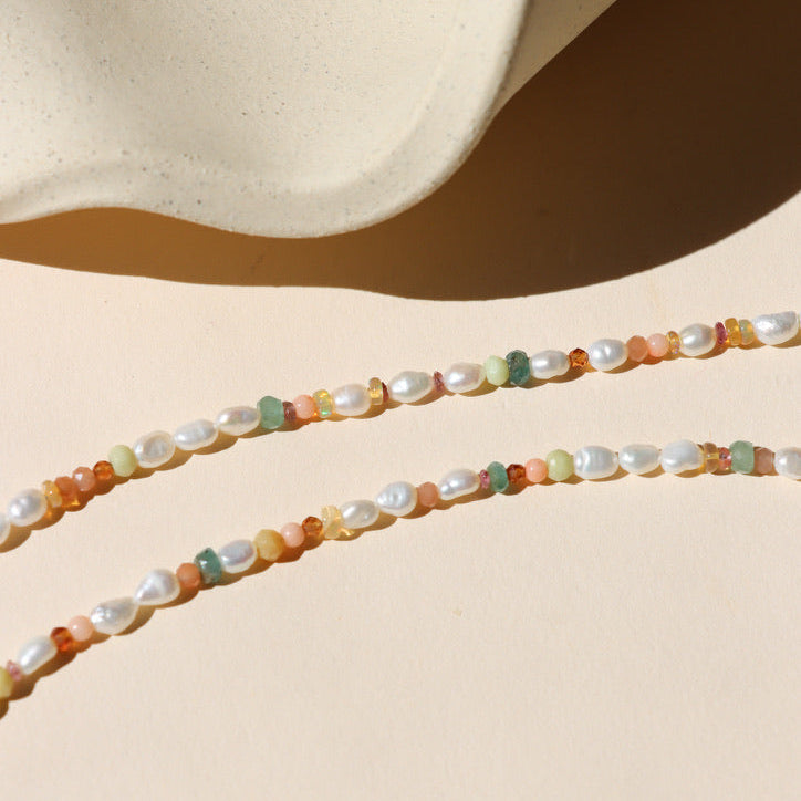 beaded gemstone & pearl necklace on a light dish