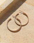 petite maeve hoops in 14k gold fill by token jewelry, a medium-sized hoop with a post, featuring a textured edge