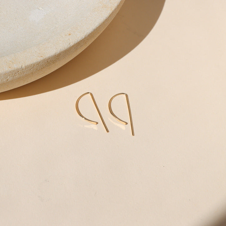 14k gold fill p shaped threader earrings on a light surface