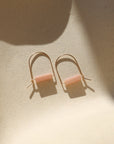 pink opal stones in 14k gold fill arch shaped earrings in the sunlight