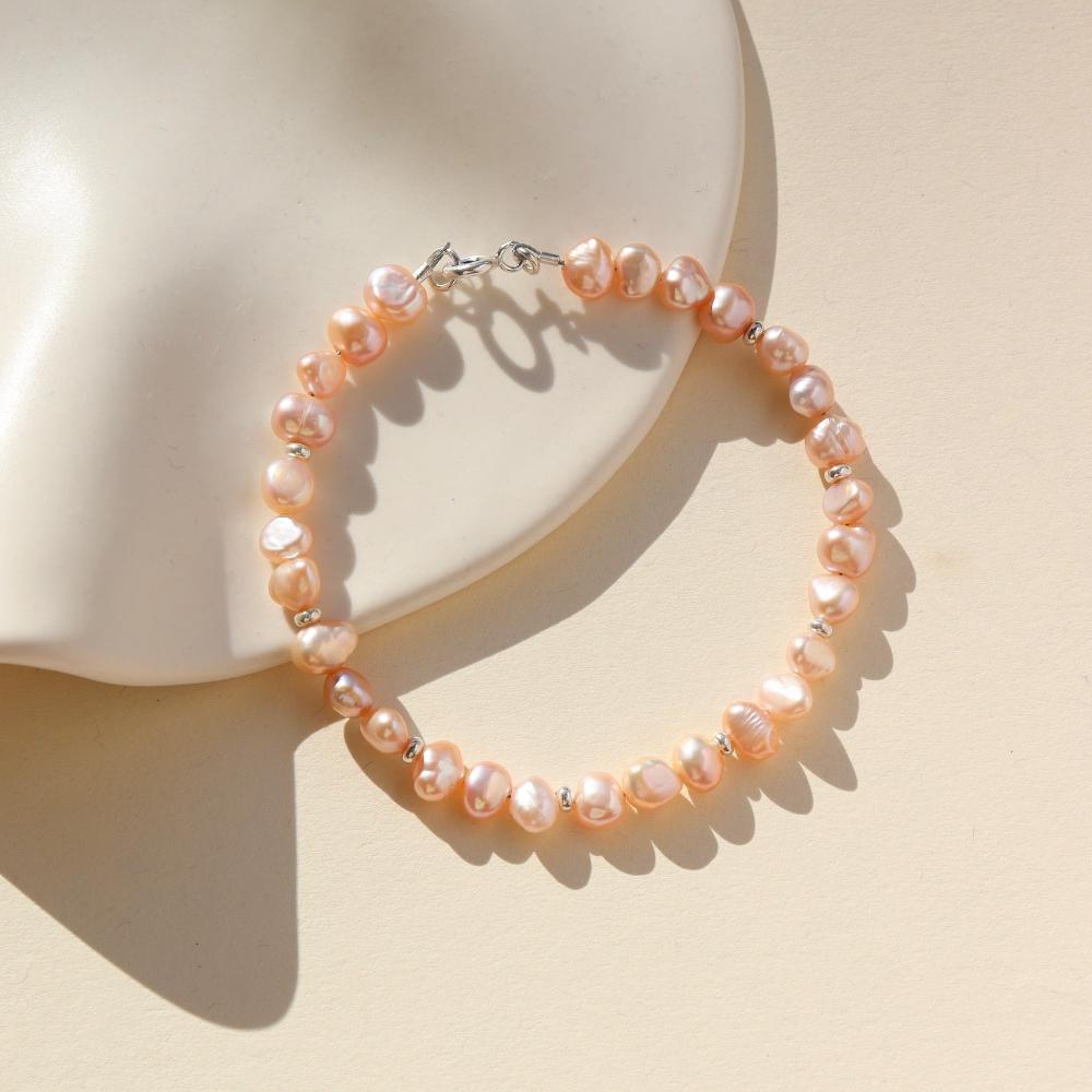 This bracelet features 29 pink pearls with a small silver bead inbetween each three pearls. This bracelet includes a silver clasp and extender. 