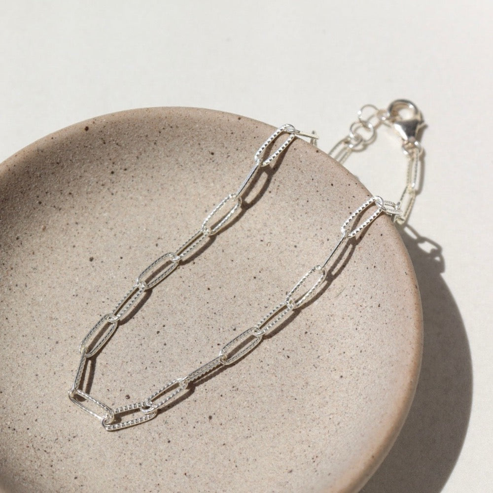 sterling silver textured paperclip chain anklet on a light dish