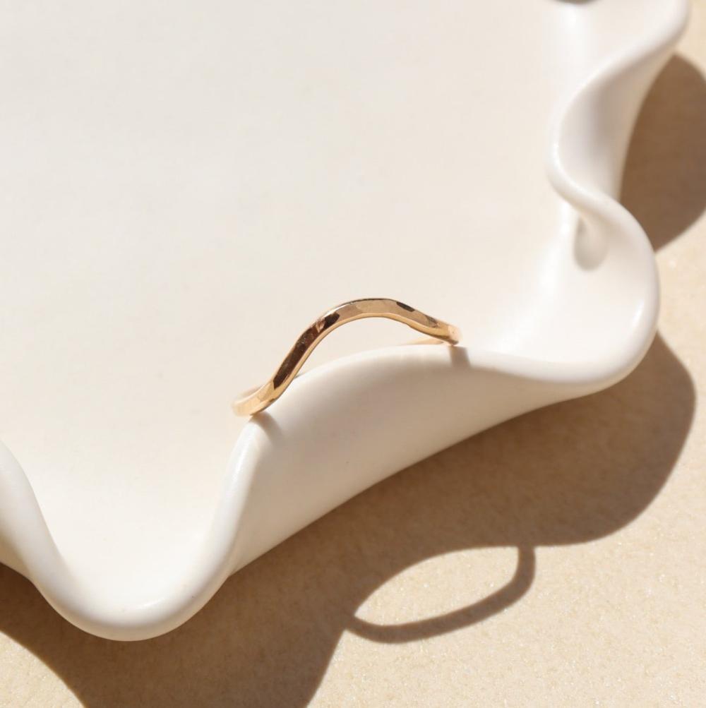 14k gold fill hammered ring with plunge detail on a light dish