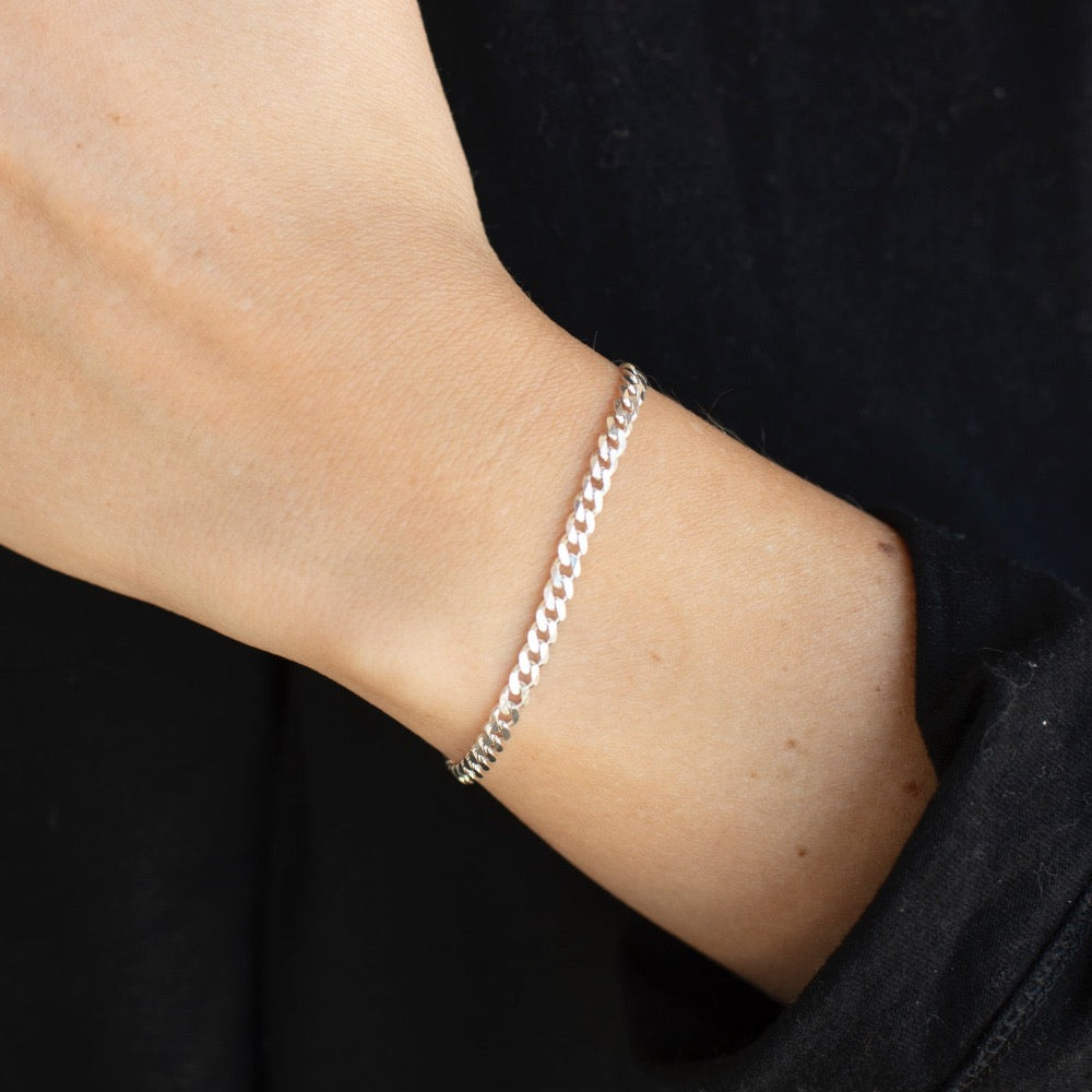 925 sterling silver cuban style chain link bracelet, worn by a model sporting a black sweater