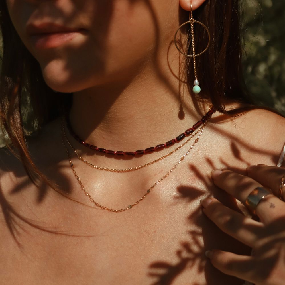 model wearing 14k gold fill hoops with pearls and turquoise beads with beaded garnet necklace and chain necklaces