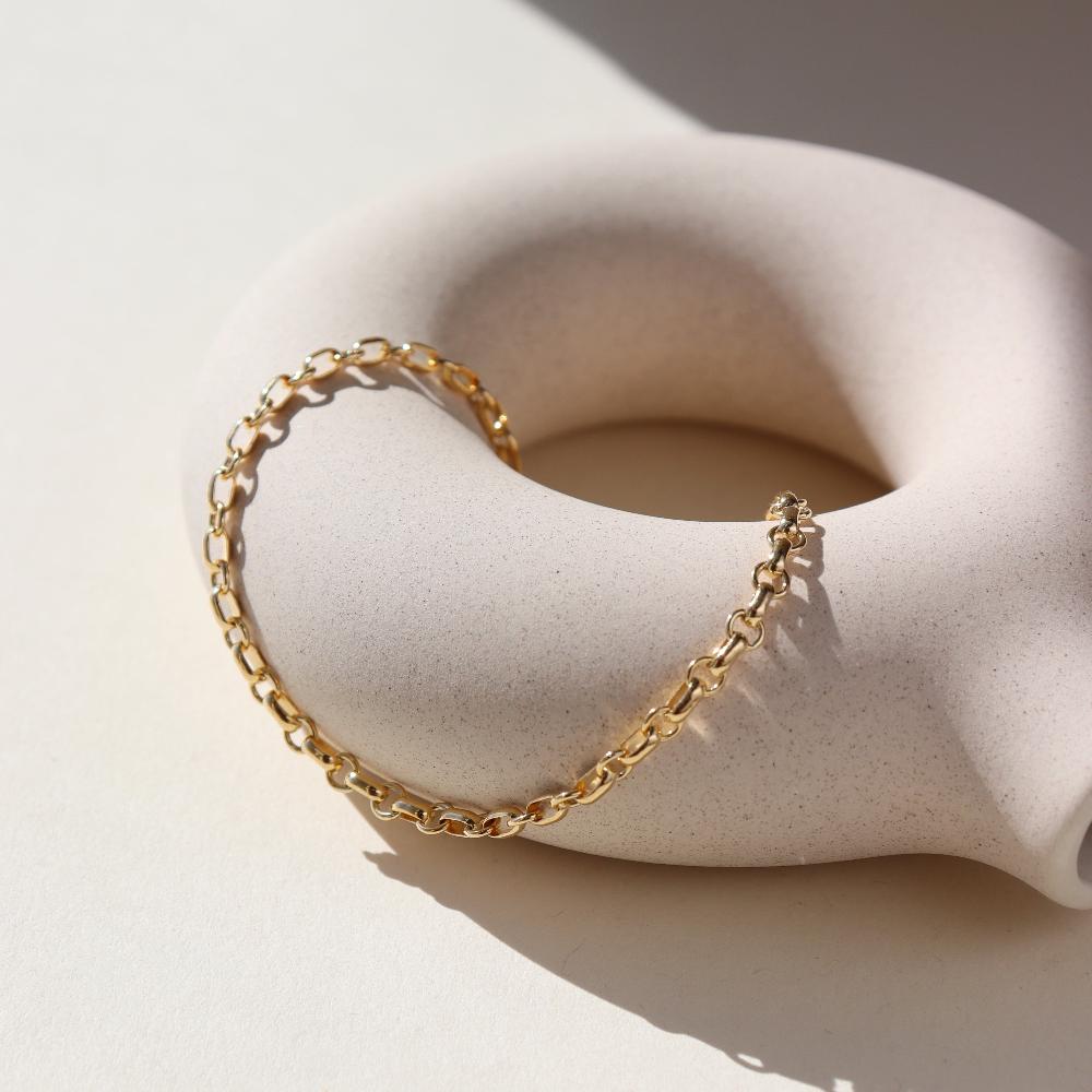 Roen Bracelet laid on a tan plate in the sunlight