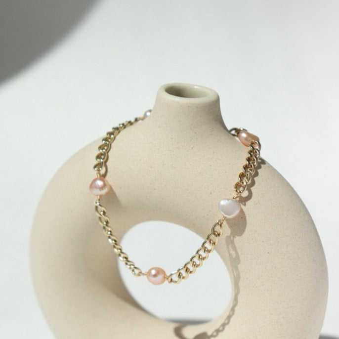 14k gold fill Rosalie Bracelet laid on a tan pot in the sunlight.