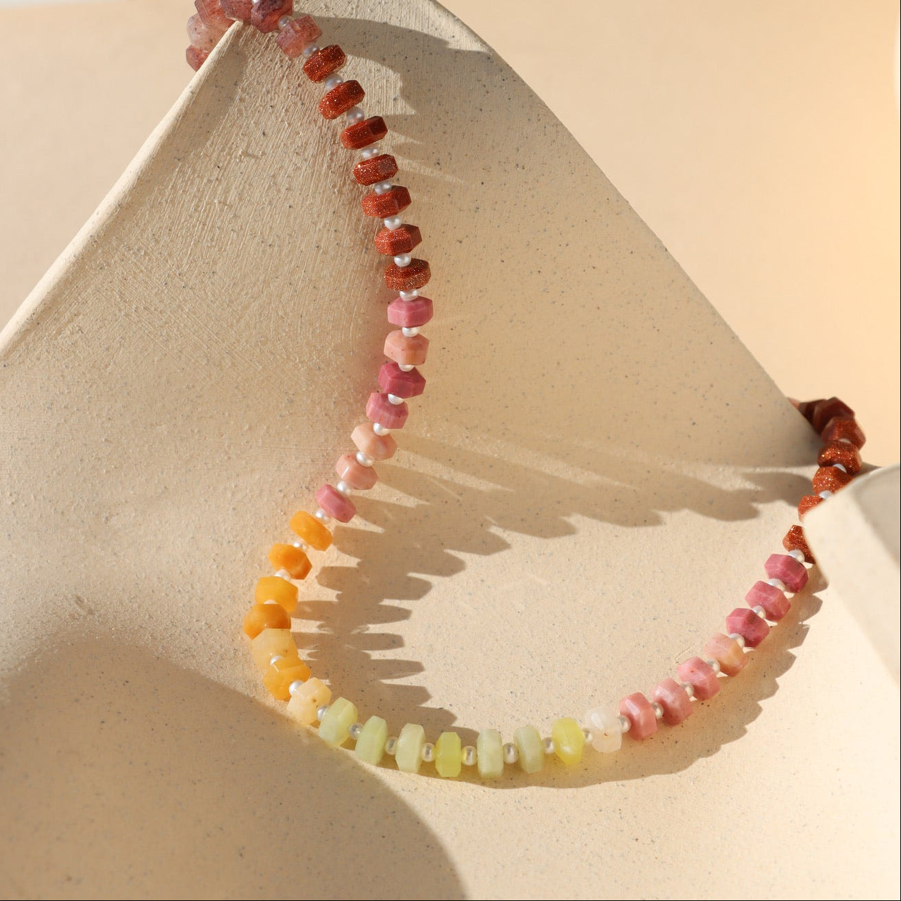 multi colored stone beads with pearls necklace displayed in the sunlight